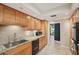 Kitchen featuring tile backsplash, granite countertops, stainless sink and appliances, and warm cabinetry at 3006 Wister Cir, Valrico, FL 33596