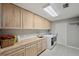 Well-lit laundry room with tile floors, wood cabinets, and a washing machine at 3006 Wister Cir, Valrico, FL 33596