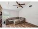 Cozy living room with wood-look floors, a large window, and an oversized sectional sofa at 3006 Wister Cir, Valrico, FL 33596