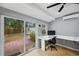 Bright office with backyard view from sliding glass doors and modern desk with ceiling fan at 3006 Wister Cir, Valrico, FL 33596