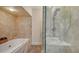 Bright bathroom featuring tiled shower, and a soaking tub provides a relaxing bathing experience at 33 Bishops Court Rd # 118, Osprey, FL 34229