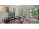 Bright dining room featuring a large glass-top table and sliding glass doors to a patio area at 33 Bishops Court Rd # 118, Osprey, FL 34229