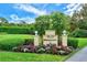 Community entrance sign featuring colorful flowers and lush landscaping at 33 Bishops Court Rd # 118, Osprey, FL 34229