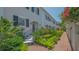 Attractive exterior with brick walkway surrounded by well-maintained landscaping and flowering plants at 33 Bishops Court Rd # 118, Osprey, FL 34229