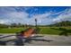 Picturesque golf course view with a clock tower, stairs, and lush green landscape at 33 Bishops Court Rd # 118, Osprey, FL 34229