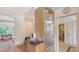 Bright eat-in kitchen with stainless steel refrigerator, tile floors, and open doorway at 33 Bishops Court Rd # 118, Osprey, FL 34229
