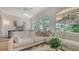 Spacious living room featuring a white sectional sofa and large windows with backyard views at 33 Bishops Court Rd # 118, Osprey, FL 34229