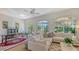 Bright living room with a white couch, rug, and arched windows looking to the outside at 33 Bishops Court Rd # 118, Osprey, FL 34229