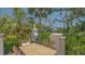 Outdoor patio features a dining table and BBQ, overlooking tropical landscaping and a pond at 33 Bishops Court Rd # 118, Osprey, FL 34229