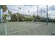 Well-maintained tennis court surrounded by lush greenery and tall palm trees at 33 Bishops Court Rd # 118, Osprey, FL 34229