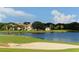 Picturesque lake view of a home, showcasing lush greenery, a sand trap, and scenic landscaping at 33 Bishops Court Rd # 118, Osprey, FL 34229