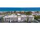 A beautiful aerial view of a beachfront apartment complex with stunning ocean views and palm trees at 3320 Gulf Of Mexico Dr # 307C, Longboat Key, FL 34228