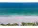 Serene aerial view of a pristine beach with clear turquoise water, perfect for relaxing or water sports at 3320 Gulf Of Mexico Dr # 307C, Longboat Key, FL 34228