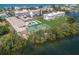 Aerial view of the condo community with a swimming pool, tennis court, and marina access at 3320 Gulf Of Mexico Dr # 307C, Longboat Key, FL 34228