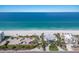 Aerial of a stunning beachfront house with palm trees, lush landscaping and ocean views at 3320 Gulf Of Mexico Dr # 307C, Longboat Key, FL 34228