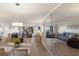 Inviting living room featuring stylish sofas, modern decor, dining table and a mirrored wall at 3320 Gulf Of Mexico Dr # 307C, Longboat Key, FL 34228