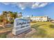 Longboat Arms community sign amidst a lush green lawn and tropical palm trees under a bright sky at 3320 Gulf Of Mexico Dr # 307C, Longboat Key, FL 34228