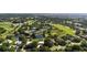 Aerial view of an expansive community, golf course, tennis courts, and ponds, showcasing the property's prime location at 3362 Charles Macdonald Dr, Sarasota, FL 34240