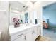 Bathroom featuring a vanity with white cabinets, a large mirror, and an open doorway to a bedroom at 3362 Charles Macdonald Dr, Sarasota, FL 34240