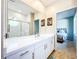 Bathroom with a white vanity, large mirror, and doorway leading into a bedroom at 3362 Charles Macdonald Dr, Sarasota, FL 34240