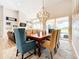 Elegant dining room with a wooden table, decorative chandelier, and view of the outdoor pool area at 3362 Charles Macdonald Dr, Sarasota, FL 34240