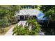 Stunning home with a paver driveway and lush landscaping, with golf course and pond views in the background at 3362 Charles Macdonald Dr, Sarasota, FL 34240