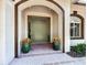Inviting front entrance featuring double doors, fresh greenery, arched doorway, and a charming brick walkway at 3362 Charles Macdonald Dr, Sarasota, FL 34240