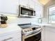 Close-up of the stylish kitchen with stainless steel stove, microwave, and white countertops at 3362 Charles Macdonald Dr, Sarasota, FL 34240