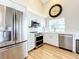 Modern kitchen boasts stainless steel appliances, white cabinets, and light wood floors at 3362 Charles Macdonald Dr, Sarasota, FL 34240