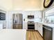 Modern kitchen featuring stainless appliances and white cabinetry with wood-look flooring at 3362 Charles Macdonald Dr, Sarasota, FL 34240