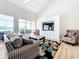 Bright living room boasts an entertainment center and sliding glass doors leading to outdoor living spaces at 3362 Charles Macdonald Dr, Sarasota, FL 34240