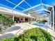 Screened in pool area surrounded by lush landscaping and an outdoor seating area at 3362 Charles Macdonald Dr, Sarasota, FL 34240