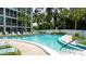 Community pool surrounded by lounge chairs and lush landscaping on a sunny day at 3740 Lake Bayshore Dr # 501, Bradenton, FL 34205