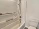 Bathroom featuring white bathtub, shower, toilet, and chrome grab bars for accessibility at 383 Bobby Jones Rd # 383, Sarasota, FL 34232