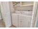 Laundry room with white washer, dryer, and built-in shelving for storage at 383 Bobby Jones Rd # 383, Sarasota, FL 34232