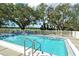 A pristine pool with ample space is enhanced by landscaping and golf course in the distance at 383 Bobby Jones Rd # 383, Sarasota, FL 34232