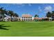 Spacious clubhouse on a meticulously maintained lawn, under a blue sky with palm trees at 385 N Point Rd # 503, Osprey, FL 34229