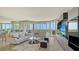 Spacious living room with water view, stylish furniture, and a modern entertainment center at 385 N Point Rd # 503, Osprey, FL 34229