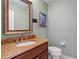 Cozy half bathroom featuring granite countertops and framed mirror at 3936 Spyglass Hill Rd, Sarasota, FL 34238