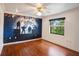 Bedroom with hardwood floors and a unique mural wall design, complemented by a window for natural light at 3936 Spyglass Hill Rd, Sarasota, FL 34238