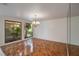 Bright dining room with a large window offering natural light, hardwood floors, and a decorative chandelier at 3936 Spyglass Hill Rd, Sarasota, FL 34238