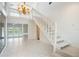 Spacious foyer with white tile flooring, staircase, and chandelier at 3936 Spyglass Hill Rd, Sarasota, FL 34238