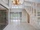 Bright foyer with white tile flooring, a staircase, and an atrium window at 3936 Spyglass Hill Rd, Sarasota, FL 34238