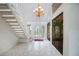 Elegant foyer featuring white tile, a grand staircase, a chandelier, and atrium views at 3936 Spyglass Hill Rd, Sarasota, FL 34238