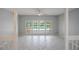 Bright living room with white tile floors, white walls, and views of the outdoor pool through french doors at 3936 Spyglass Hill Rd, Sarasota, FL 34238