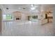 Bright open-concept kitchen, dining, and living space with a stone fireplace and white tile flooring at 3936 Spyglass Hill Rd, Sarasota, FL 34238