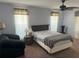 Simple bedroom with a cozy seating area, decorative lamps, ceiling fan and natural light at 40 Mariner Ln, Rotonda West, FL 33947
