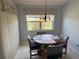 Cozy dining area featuring a round wood table, chandelier, and natural light from the window at 40 Mariner Ln, Rotonda West, FL 33947