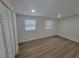 Bedroom with wood floors, two windows, and a closet with white doors at 4210 Baird St, Sarasota, FL 34232