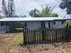 Charming single-story home with a metal roof, carport, and picket fence at 4210 Baird St, Sarasota, FL 34232